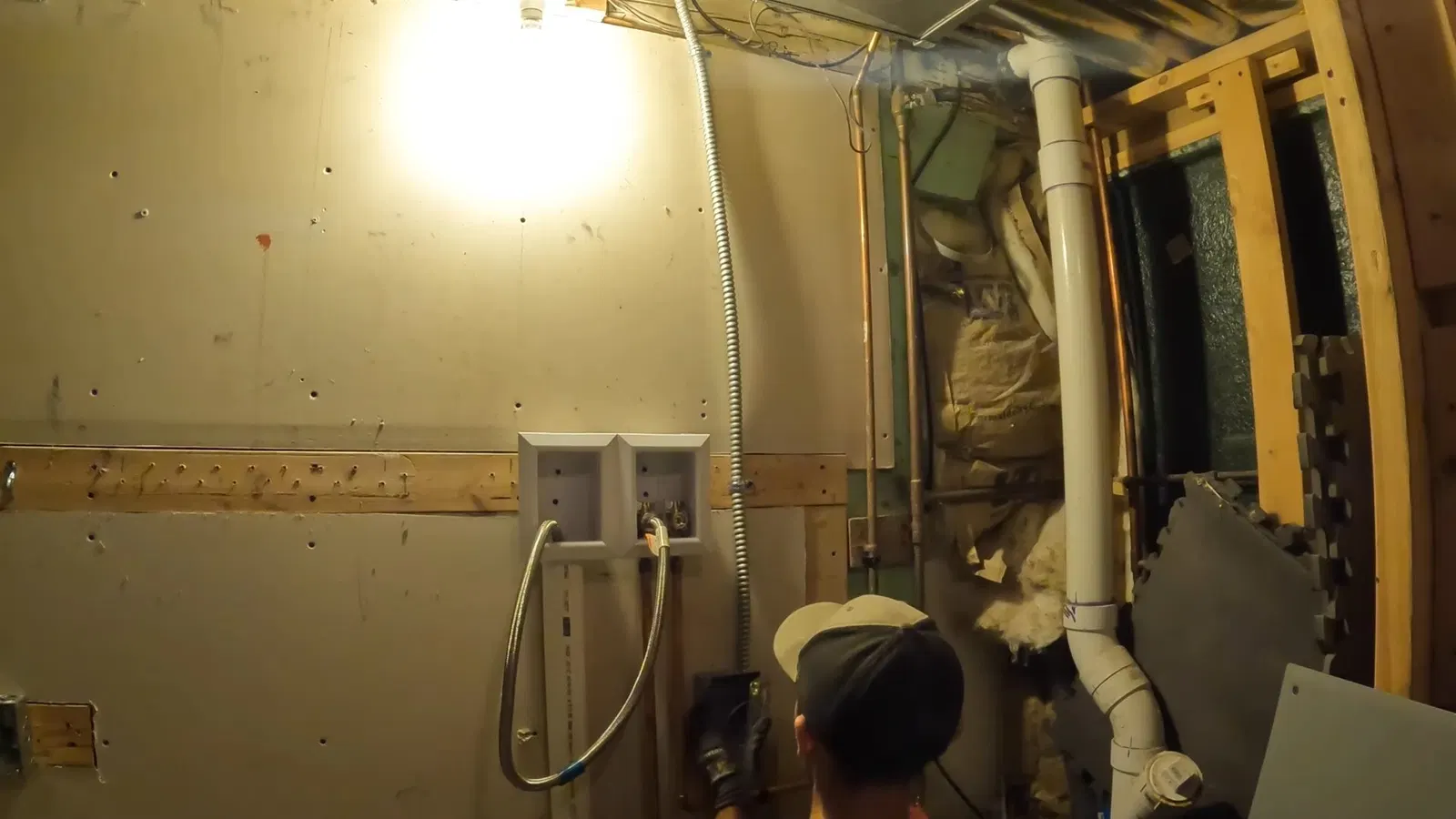 Close view of drain pipe routing for basement laundry plumbing
