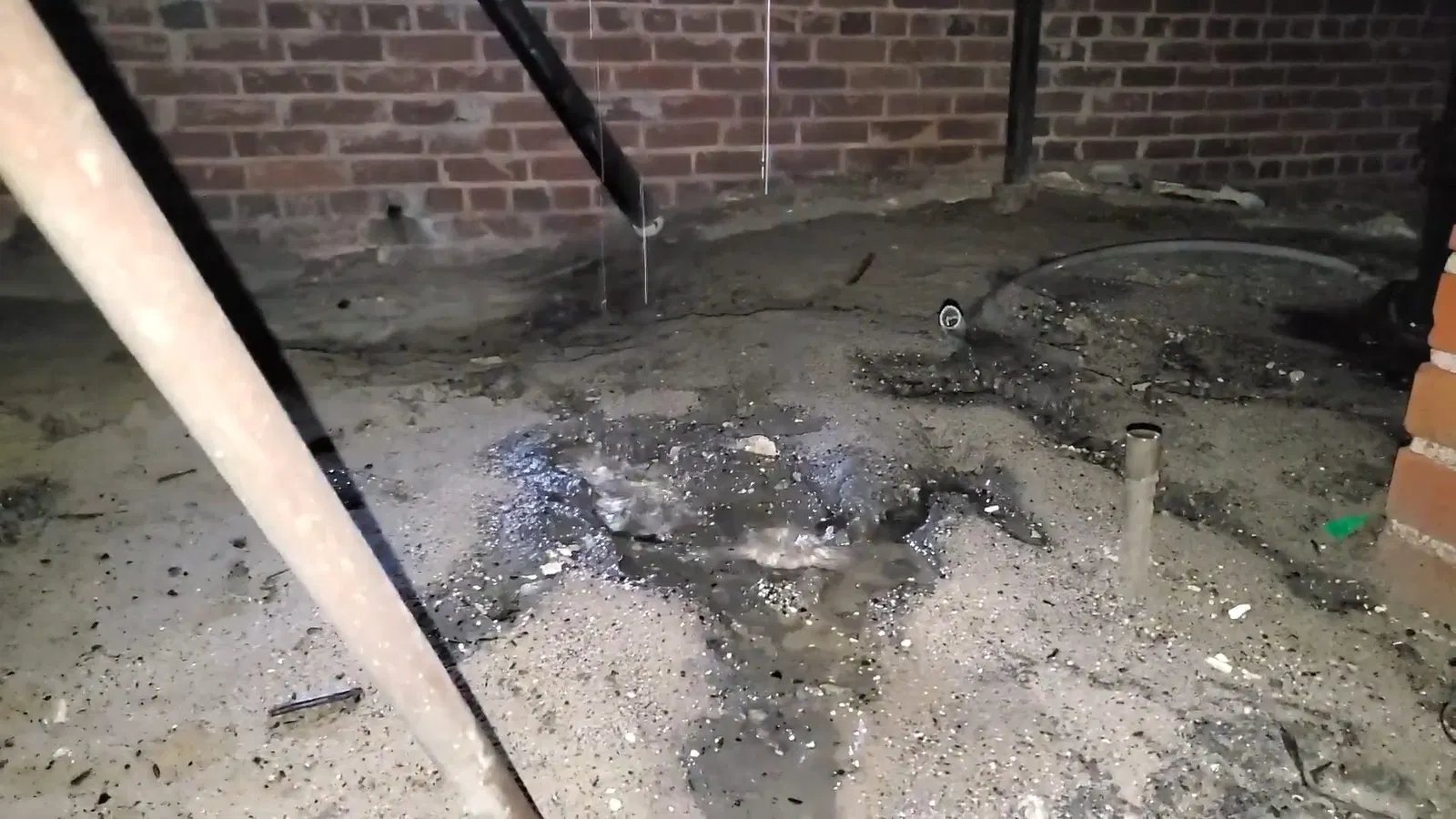 Plumbing service view of pipe slope detail in crawl space leak inspection