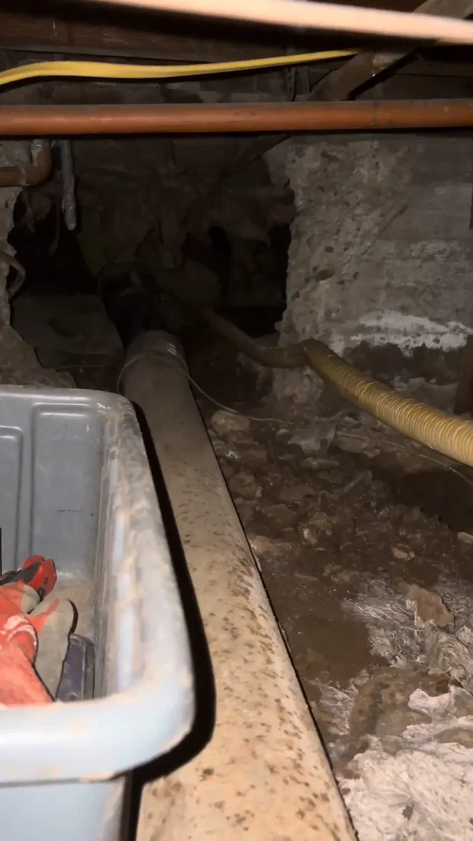 Crawl space sewer piping showing drain pipe routing