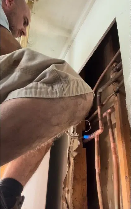 Plumbing leak detection showing moisture meter check