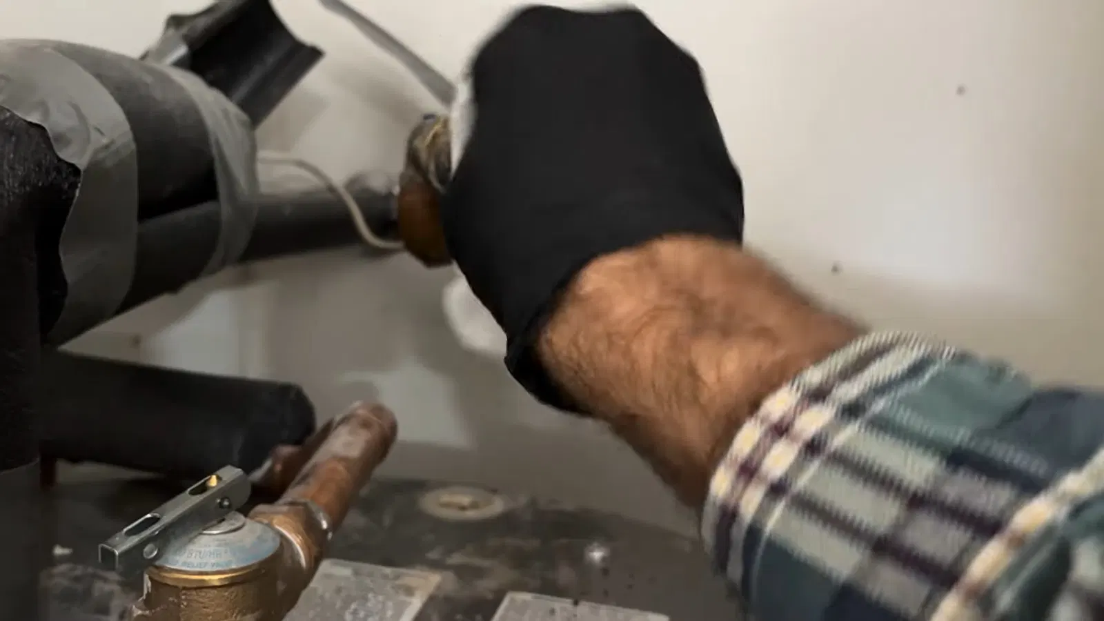 Plumbing service view of drain valve in water heater inlet connection repair